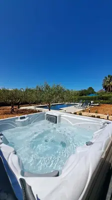 a jacuzzi tub in a resort with trees at Villa Betta Cuntrariusa con piscina privata e jacuzzi a Scopello in Castellammare del Golfo
