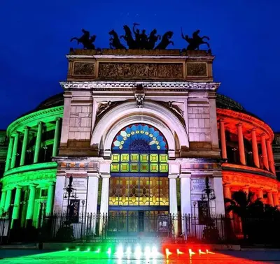a building lit up at night with green lights at B&B Alla Stazione in Palermo