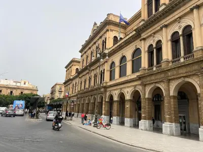 a large building on a city street with people on motorcycles at B&B Alla Stazione in Palermo