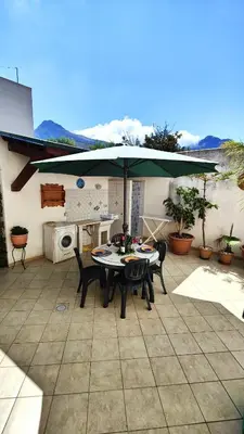 a table and chairs under an umbrella on a patio at Casa Bougainville, Mare e Relax in San Vito lo Capo