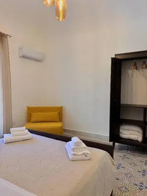 a bedroom with a bed and a yellow couch at Expo1891 in Palermo