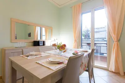 a dining room with a table with chairs and a window at Casetta Tiffany Mondello in Mondello