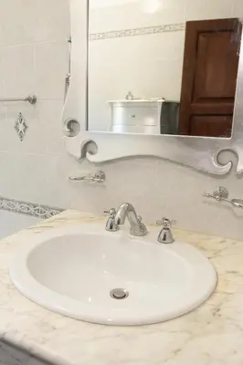 a white sink in a bathroom with a mirror at Appartamento centrale 2 camere a Termini Imerese - Marconi House in Termini Imerese