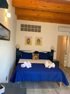 a bedroom with a blue bed with two towels at U muragghiuni n3 in Lascari