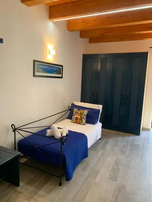 a bedroom with a bed with blue sheets and black cabinets at U muragghiuni n3 in Lascari