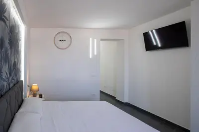 a bedroom with a bed and a clock on the wall at Santerasmo rooms Charm in Palermo