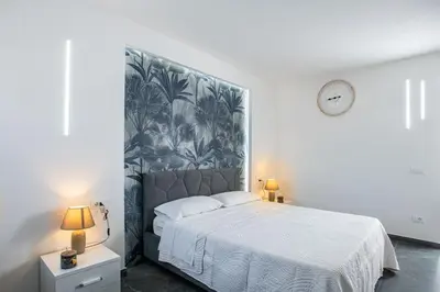 a bedroom with a large bed with a large headboard at Santerasmo rooms Charm in Palermo