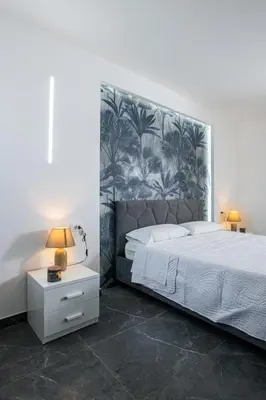 a bedroom with a large bed with a large headboard at Santerasmo rooms Charm in Palermo