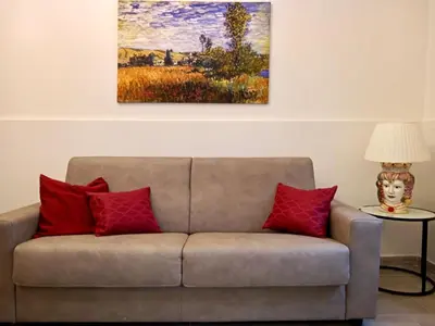 a couch with red pillows in a living room at Chez D'Ossuna con Patio Privato - centro storico Cattedrale - ampio 6 ospiti in Palermo