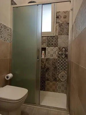 a bathroom with a shower with a toilet and a window at Chez D'Ossuna con Patio Privato - centro storico Cattedrale - ampio 6 ospiti in Palermo