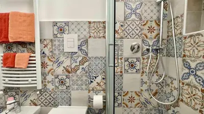 a bathroom with a shower with tiles on the wall at Chez D'Ossuna con Patio Privato - centro storico Cattedrale - ampio 6 ospiti in Palermo