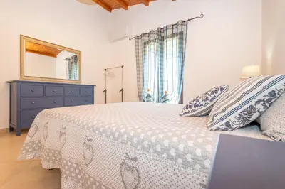a bedroom with a bed and a dresser and a mirror at Villa Deluxe in Campofelice di Roccella
