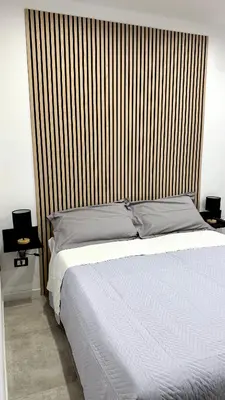 a bedroom with a large white bed with a wooden headboard at DiGi Home in Palermo
