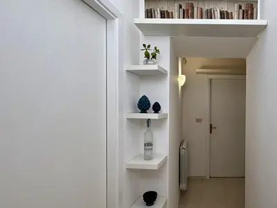 a room with white shelves and a hallway with a door at Villa GioEle - Pool & Relax in Mandra Capreria