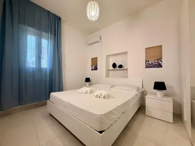 a bedroom with a white bed and a window at Villa GioEle - Pool & Relax in Mandra Capreria