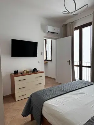 a bedroom with a bed and a flat screen tv at Domus Vucciria in Palermo