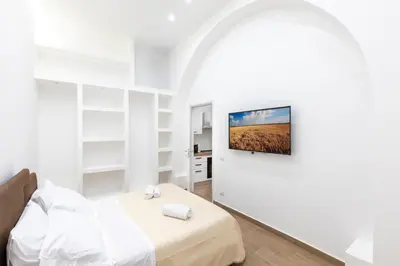 a white bedroom with a bed with towels on it at Luxury Royal House in Palermo