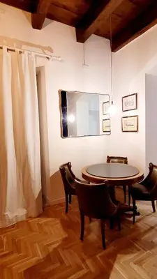 a dining room with a table and chairs and a mirror at Maison S Elena in Palermo
