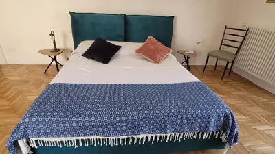 a bedroom with a bed with a blue and white comforter at Maison S Elena in Palermo