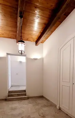 a room with white walls and a wooden ceiling at Maison S Elena in Palermo