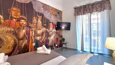a bedroom with a large painting on the wall at I Paladini ORLANDO Apartment in Palermo