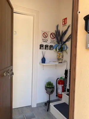 a hallway with a door and a shelf with plants at U muragliuni 2 in Lascari