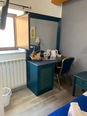 a blue desk in a room with a mirror at U muragliuni 2 in Lascari