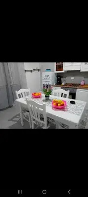 a kitchen table with chairs and a white table with flowers on it at Casa Passamonte in Palermo