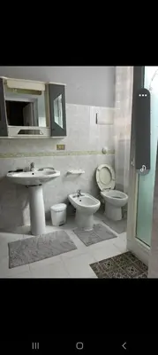 a bathroom with two sinks and a toilet and a mirror at Casa Passamonte in Palermo