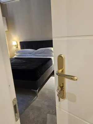 a bedroom with a bed and a table and windows at Magnificat in Palermo