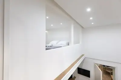 a staircase in a white room with a bed at Luxury Royal House in Palermo