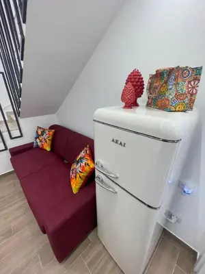 a kitchen with a refrigerator and a purple couch at Luxury Royal House in Palermo