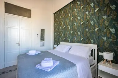 a bedroom with a blue bed with a floral wallpaper at Palermo Centro Le Cupole della Felicissima in Palermo