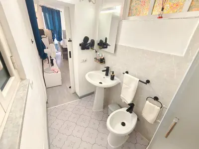 a bathroom with a white toilet and a sink at subway apartment in Palermo