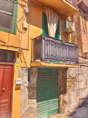 a building with a green door and a balcony at subway apartment in Palermo