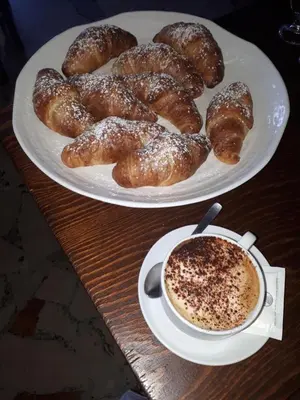 two plates of pastries and a cup of coffee on a table at Hotel Il Pirata in Cinisi