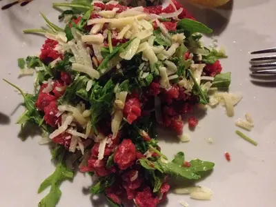 a salad on a white plate with a fork at Hotel Il Pirata in Cinisi