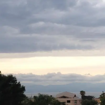 a cloudy sky with mountains in the distance at Hotel Il Pirata in Cinisi