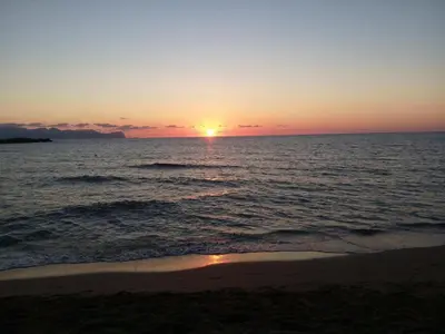 a sunset over the ocean with a beach at Hotel Il Pirata in Cinisi