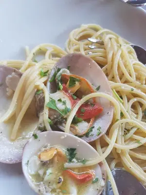 a plate of food with spaghetti and oysters at Hotel Il Pirata in Cinisi