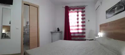 a bedroom with a bed and a red and white curtain at Aquilone in Castelluzzo