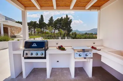 a kitchen with a counter with a stove and a window at Villa Allegra in Castellammare del Golfo