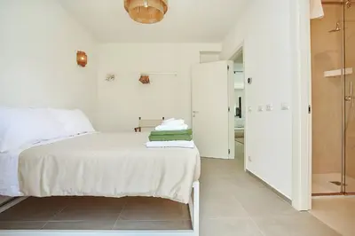 a white bedroom with a bed and a walk in closet at Villa Allegra in Castellammare del Golfo
