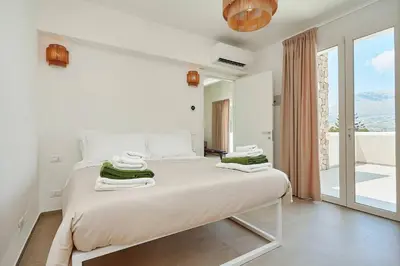 a white bedroom with a bed with towels on it at Villa Allegra in Castellammare del Golfo