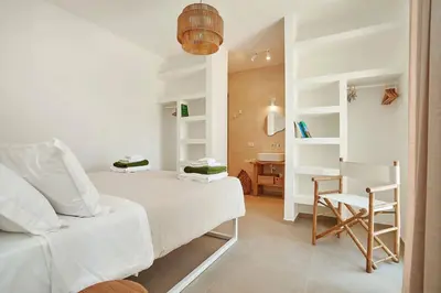 a white bedroom with a bed and a desk at Villa Allegra in Castellammare del Golfo
