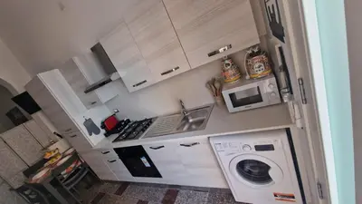 a kitchen with a washing machine and a microwave at Arena Dorada apartaments Morrocoy in Balestrate