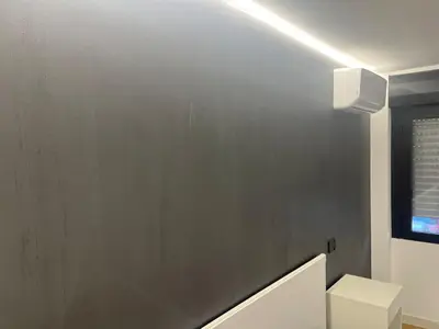 a bathroom with a gray wall and a white toilet at Suit home Archimede in Palermo