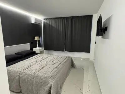 a bedroom with a bed and a black wall at Suit home Archimede in Palermo