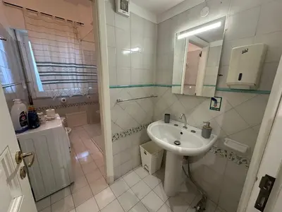 a white bathroom with a sink and a mirror at My Space in Palermo