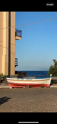 a red and white boat parked next to the ocean at ESSE Homes Sant Elia in Santa Flavia